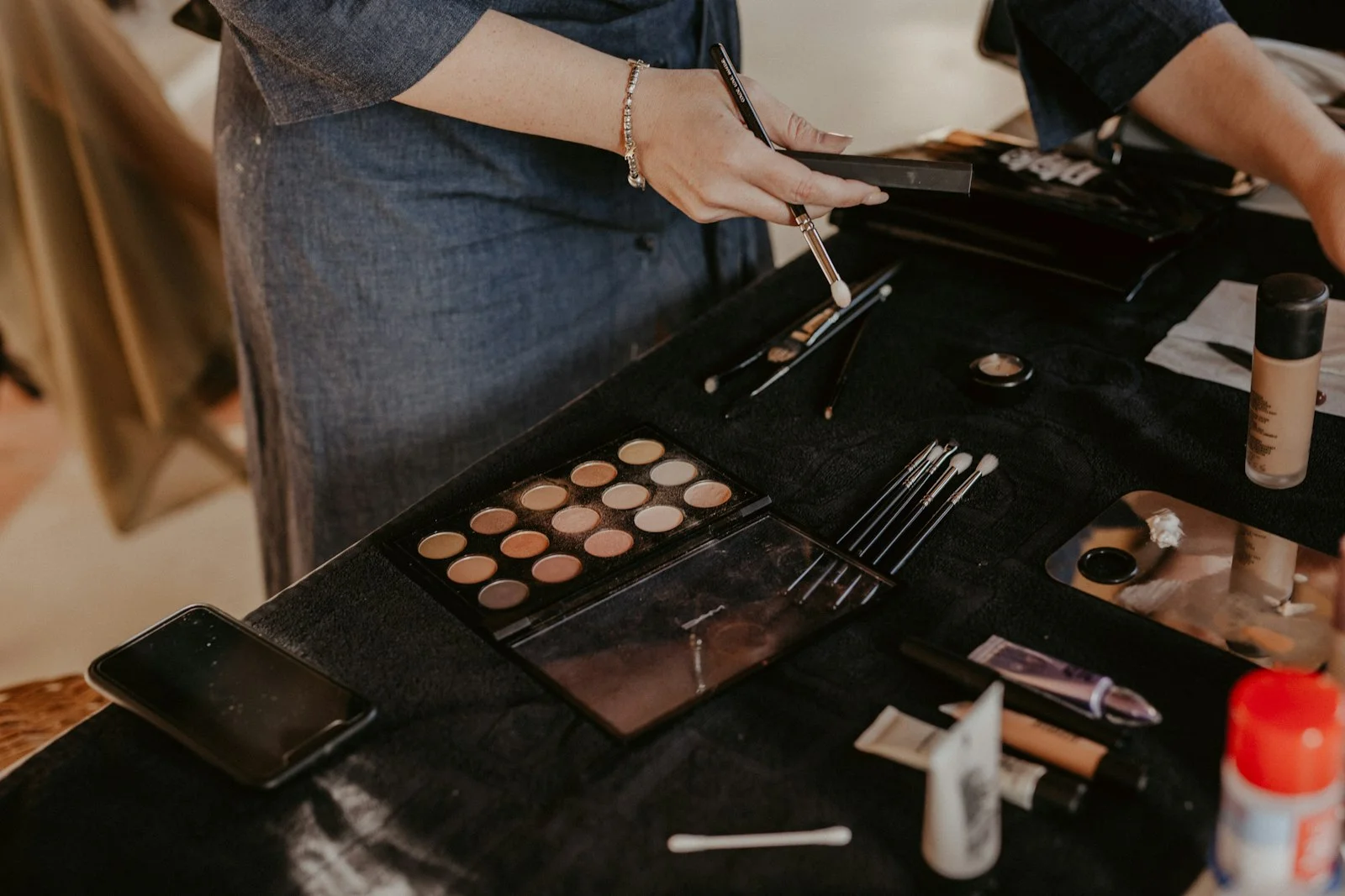 a woman is putting makeup on a table a woman is putting makeup on a table
